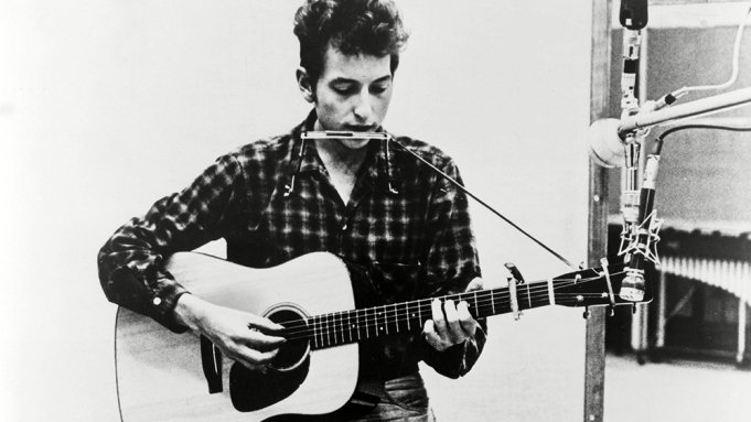 Bob Dylan håller med gitarr och munspel